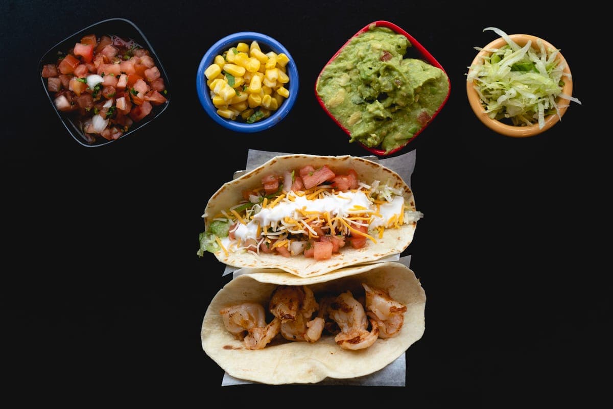 Loaded taco and shrimp taco with salsa, guacamole and corn